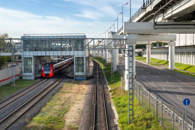 Şehrin ulaşım altyapısı. Moskova 'da bir yaz gününde kırmızı treni ve iki katlı üst geçidi olan bir metro istasyonu.