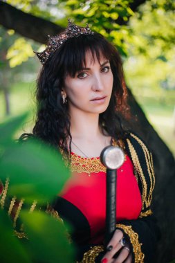 Kraliçe onu elinde bir kılıç ile. Taç güzel kız. Fantezi. Altın nakış ile Ortaçağ siyah ve kırmızı elbise.