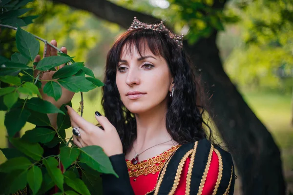Kraliçe. Taç güzel kız. Fantezi. Altın nakış ile Ortaçağ siyah ve kırmızı elbise.