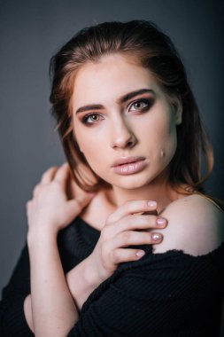 Güzel bir kızla siyah giysili bir kafatası onun elinde. Gothic Moda. Bir model gri bir arka plan üzerinde. Stüdyo portre