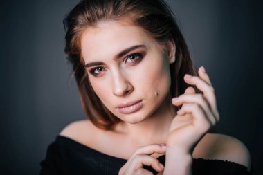 Güzel bir kızla siyah giysili bir kafatası onun elinde. Gothic Moda. Bir model gri bir arka plan üzerinde. Stüdyo portre