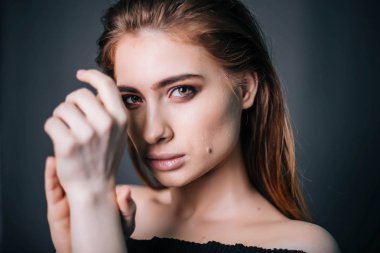 Güzel bir kızla siyah giysili bir kafatası onun elinde. Gothic Moda. Bir model gri bir arka plan üzerinde. Stüdyo portre