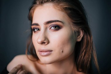 Güzel bir kızla siyah giysili bir kafatası onun elinde. Gothic Moda. Bir model gri bir arka plan üzerinde. Stüdyo portre