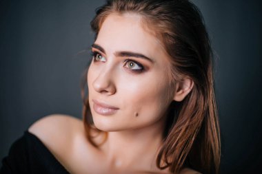 Güzel bir kızla siyah giysili bir kafatası onun elinde. Gothic Moda. Bir model gri bir arka plan üzerinde. Stüdyo portre