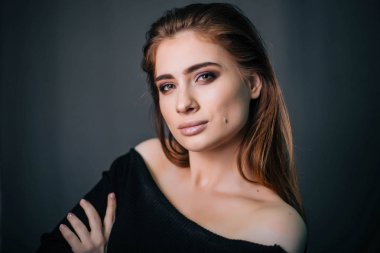 Güzel bir kızla siyah giysili bir kafatası onun elinde. Gothic Moda. Bir model gri bir arka plan üzerinde. Stüdyo portre