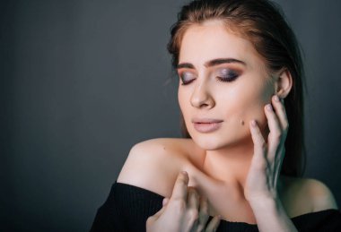 Güzel bir kızla siyah giysili bir kafatası onun elinde. Gothic Moda. Bir model gri bir arka plan üzerinde. Stüdyo portre