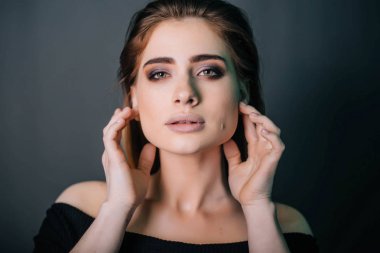 Güzel bir kızla siyah giysili bir kafatası onun elinde. Gothic Moda. Bir model gri bir arka plan üzerinde. Stüdyo portre