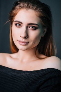 Güzellik Portresi. Stüdyo portre gri bir arka plan üzerinde güzel bir kız. İyi bir makyaj. Yüz yakın çekim