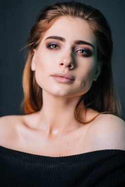 Güzellik Portresi. Stüdyo portre gri bir arka plan üzerinde güzel bir kız. İyi bir makyaj. Yüz yakın çekim