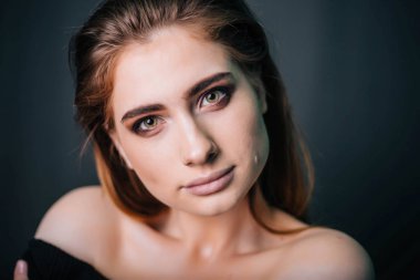 Güzellik Portresi. Stüdyo portre gri bir arka plan üzerinde güzel bir kız. İyi bir makyaj. Yüz yakın çekim