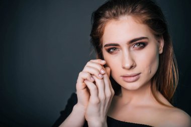 Güzellik Portresi. Stüdyo portre gri bir arka plan üzerinde güzel bir kız. İyi bir makyaj. Yüz yakın çekim