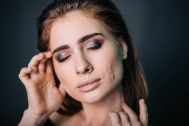 Güzellik Portresi. Stüdyo portre gri bir arka plan üzerinde güzel bir kız. İyi bir makyaj. Yüz yakın çekim