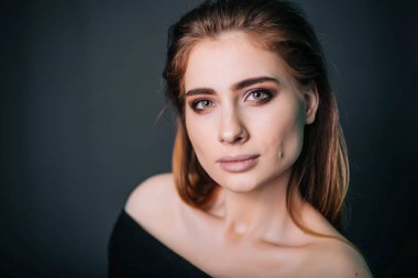 Güzellik Portresi. Stüdyo portre gri bir arka plan üzerinde güzel bir kız. İyi bir makyaj. Yüz yakın çekim