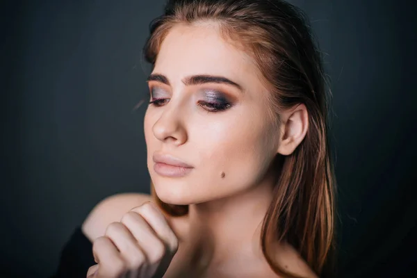 Maquiador profissional aplica maquiagem em uma modelo de menina bonita. o  rosto de uma garota de pele limpa. conceito de maquiagem e cosmetologia da  vida real. casamento, noite, maquiagem natural.