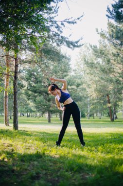 Güzel bir kız parkta spor devreye girer. Temiz cilt ve spor oboyatelnoy ulvbkoy bir model. Açık Hava eğitimleri.