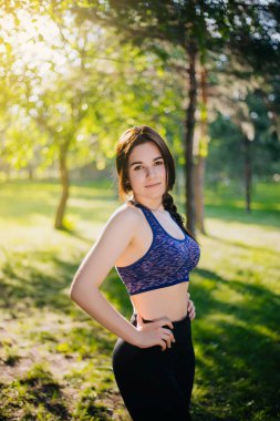 Güzel bir kız parkta spor devreye girer. Temiz cilt ve spor oboyatelnoy ulvbkoy bir model. Açık Hava eğitimleri.