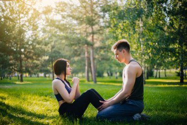 Genç kız ve adam'ın bahçesinde parkta şınav. Açık havada spor yapıyor. Spor giyim insanlarda egzersizleri yapın