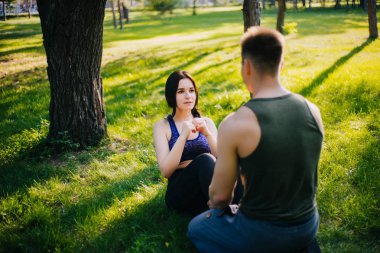 Genç kız ve adam'ın bahçesinde parkta şınav. Açık havada spor yapıyor. Spor giyim insanlarda egzersizleri yapın