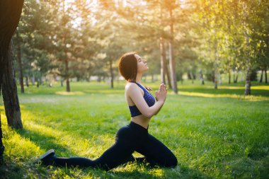 Genç güzel kız parkta Yoga uygulamak. Spor giyim kadın. Sağlıklı yaşam tarzı.