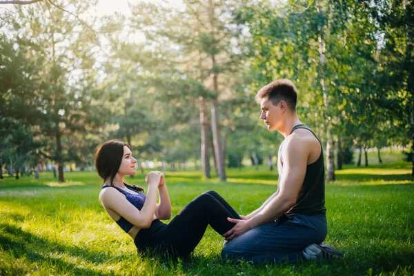 Genç kız ve adam'ın bahçesinde parkta şınav. Açık havada spor yapıyor. Spor giyim insanlarda egzersizleri yapın