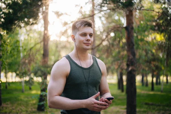 Joven Guapo Selecciona Música Smartphone Hombre Con Auriculares Con Teléfono — Foto de Stock