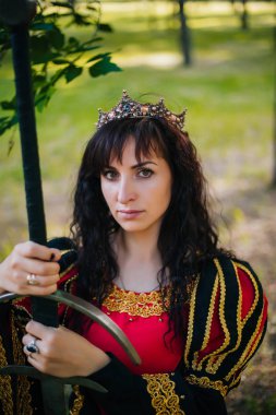Kraliçe onu elinde bir kılıç ile. Taç güzel kız. Fantezi. Altın nakış ile Ortaçağ siyah ve kırmızı elbise.
