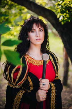 Kraliçe onu elinde bir kılıç ile. Taç güzel kız. Fantezi. Altın nakış ile Ortaçağ siyah ve kırmızı elbise.