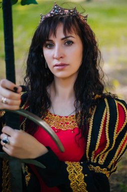 Kraliçe onu elinde bir kılıç ile. Taç güzel kız. Fantezi. Altın nakış ile Ortaçağ siyah ve kırmızı elbise.