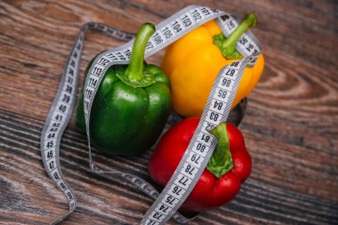 Diet bell pepper multicolored on a dark wooden background. Red, yellow and green peppers are on the table with