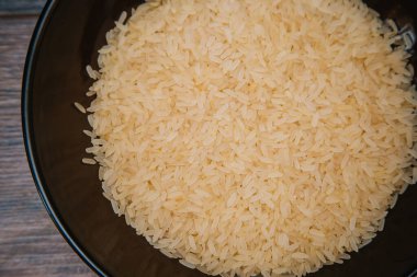 Rice in a dark cup. Ingredients for the dish.