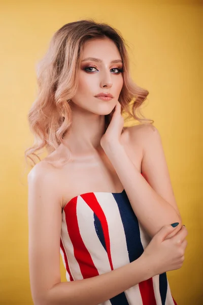 Krásná, mladá modelka, blond portrét zblízka. Dívka s profesionální make-up a účes, studio foto na žlutém pozadí. Módní fotografie — Stock fotografie