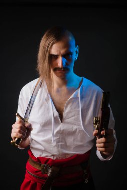 Ulusal Ukrayna giysileri içinde silahlarla Kozak. Beyaz gömlekli, kırmızı kemerli genç bir adam, bir kılıç ve bir tabanca tutuyor..