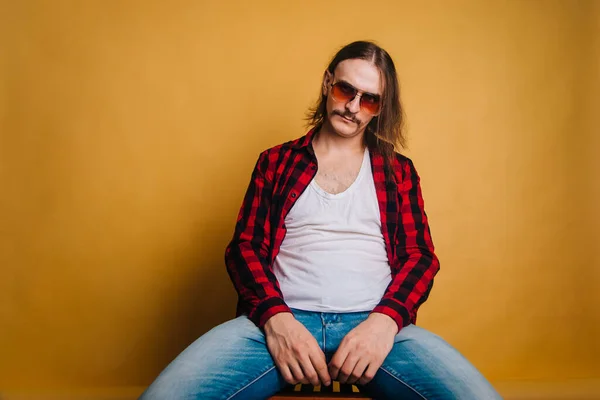 Atrakcyjny Mężczyzna Długimi Włosami Wąsami Czerwonej Bluzce Disco Lat Siedzący — Zdjęcie stockowe