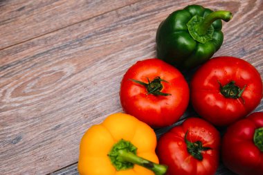 Koyu ahşap arka planda kırmızı domates ve renkli dolma biber..