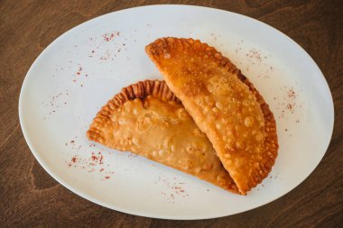 Ulusal mutfak. Kızarmış cheburek ve et. Beyaz bir tabakta kıymalı börek.
