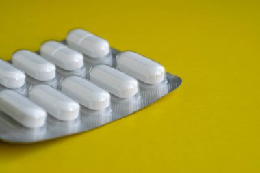 Sarı arka planda hapları olan bir tabağın parçası ve metin için yer