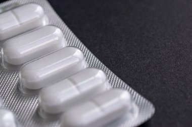 Siyah arka planda hapları olan bir tabağın parçası. Yakın plan ve metin için yer