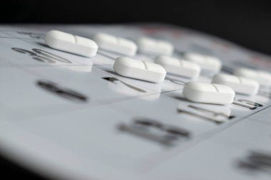 Takvim kağıdında beyaz tabletler yuvarlak