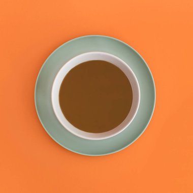 Yeşil ışıklı tabakta çikolata kasesi. Turuncu arka plan. Üst Manzara. Boşluğu kopyala