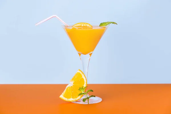 オレンジの表面にスライスとミントの葉をベースにしたフレッシュオレンジジュースとライトブルーの背景 — ストック写真