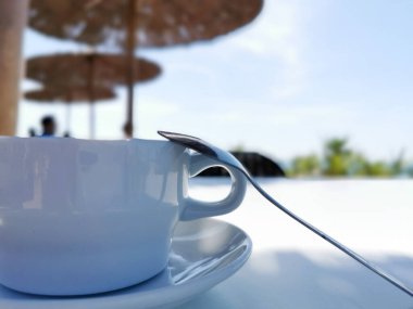 Denizin arka planına ve sahil kafesine karşı bir fincan kahve. Akdeniz 'de İspanyol Yazı