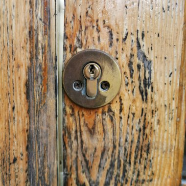 Eski ahşap bir panele kilitlenmiş anahtar deliği.