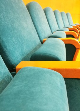 Boş bir konferans odasında mavi koltuklar.