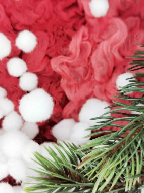 Ladin dalı, beyaz pamuk topları ve kırmızı buruşuk kumaş arkaplanda Yeni Yıl arkaplan ve dekorasyonları için