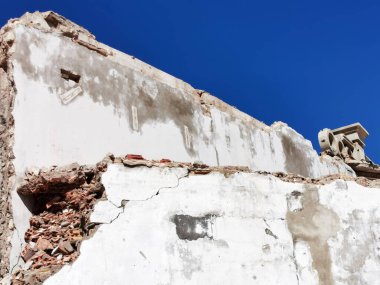 Kırık tuğla ve destek parçalarıyla yıkılmış tuğla ev duvarı.