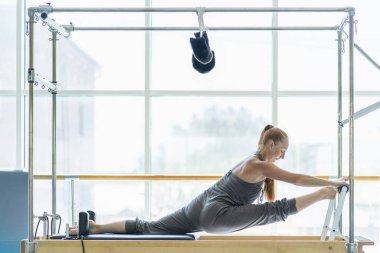 Kadın pilates yatağında geriniyor..