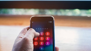 Şifreyi girerken el ele tutuşan akıllı telefon