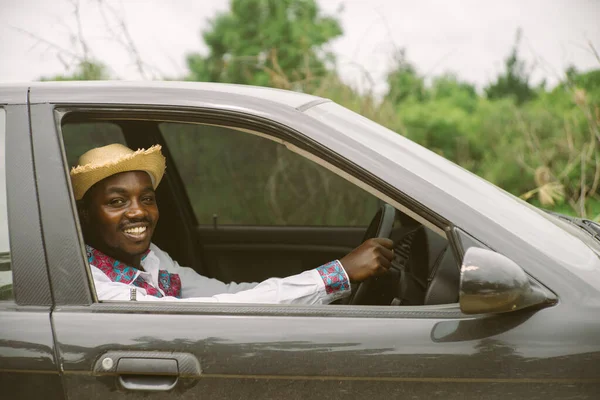 坐在开着前窗的车上时 非洲司机笑了 — 图库照片