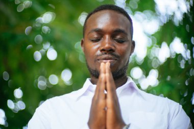 Afrikalı adam yeşil doğada Tanrı 'ya dua ediyor.
