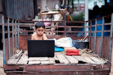 Küçük çocuk bilgisayarla internetten izliyor ve öğreniyor.